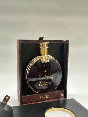 un flacon de parfum posé dans une boîte avec une bague