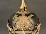 an old helmet on a stand with a gold hat on top