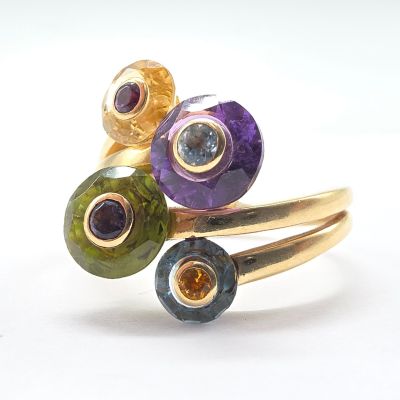 a close up of a ring with different colored stones on it