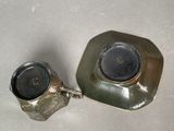 a silver cup and saucer sitting on a table