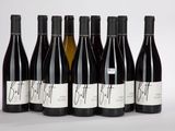 six bouteilles de vin sont alignées sur une table