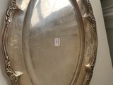 an antique silver plate hanging on a wall next to a window
