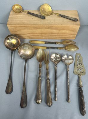 Plusieurs cuillères et fourchettes sont disposées sur une table
