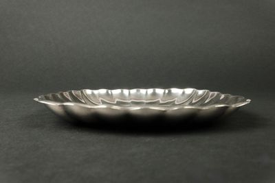 un gros plan d'une assiette en argent posée sur une surface noire