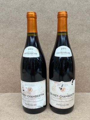deux bouteilles de vin posées sur une table l'une à côté de l'autre