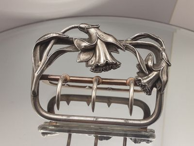 un plat en argent surmonté d'un oiseau
