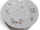 a stack of white plates with pink flowers on them