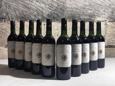 six bottles of wine are lined up in a row against a stone wall