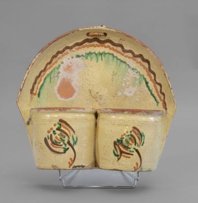 an image of a yellow vase with a green and red design