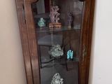a corner cabinet with a glass door in the corner of the room