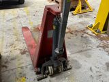un chariot élévateur dans un garage, avec une camionnette en arrière-plan
