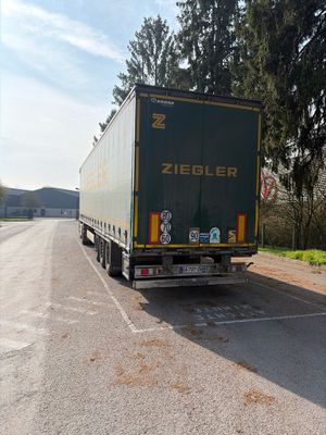 un camion qui roule sur la route pendant la journée