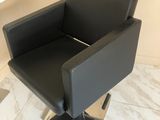 une chaise noire posée sur un sol en marbre
