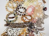 a close up of a pile of jewelry on a white surface