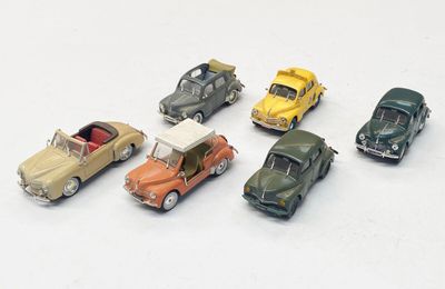 plusieurs petites voitures sont alignées sur une surface blanche