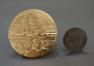 a gold coin next to a silver coin on a table