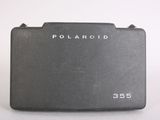an old polaroid camera sitting on top of a white surface
