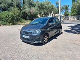 une voiture grise garée sur un parking près d'une clôture