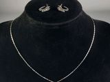 un gros plan d'un ensemble composé d'un collier et de boucles d'oreilles porté par un mannequin