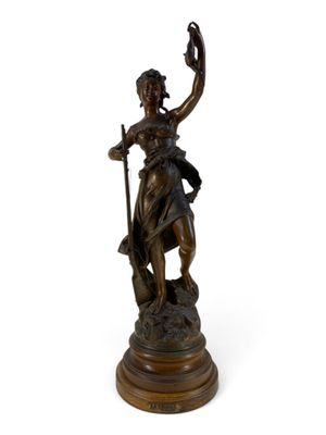an antique bronze statue of a woman holding a staff on a pedestal