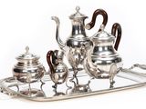 a silver tea set on a tray on a white background