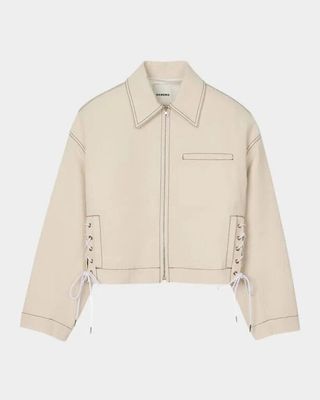 une veste blanche avec des lacets aux manches et aux poignets