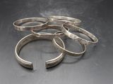a close up of a bunch of silver rings on a table