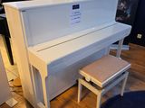 un piano blanc et un tabouret dans une pièce