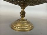 an image of a gold bowl on a table with a white background