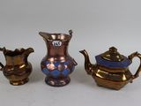 three pieces of antique brass and blue glass on a white surface