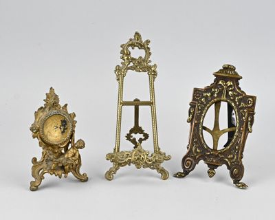trois horloges miniatures sont posées les unes à côté des autres sur une surface blanche