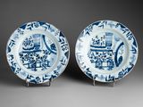 pair of blue and white plates with figures and flowers