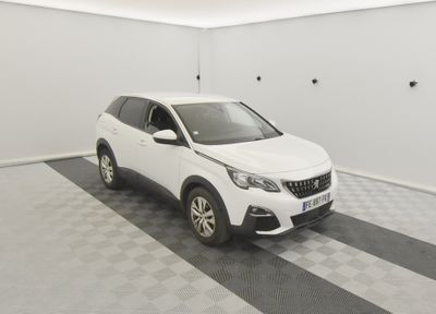 une voiture blanche garée dans un garage au sol en damier