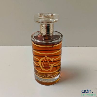 une photo d'un flacon de parfum posé sur une table
