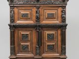 une vieille armoire en bois avec des sculptures et des gravures sur les portes