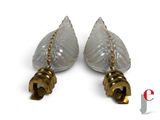 pair of clear glass lamps with gold chains on them on a white surface