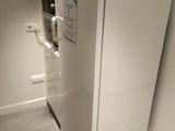 un réfrigérateur blanc et des toilettes dans une petite pièce