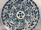 a close up of a blue and white plate with flowers on it