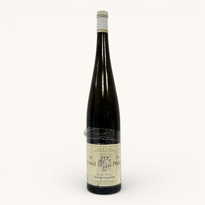 une vieille bouteille de vin posée sur une surface blanche