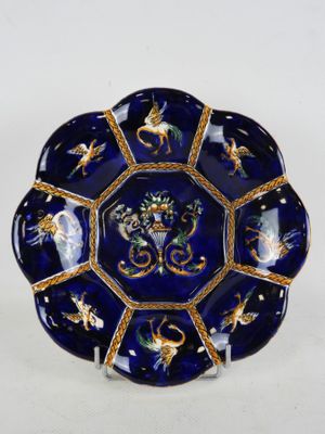 une image représentant une assiette bleue et dorée ornée d'oiseaux