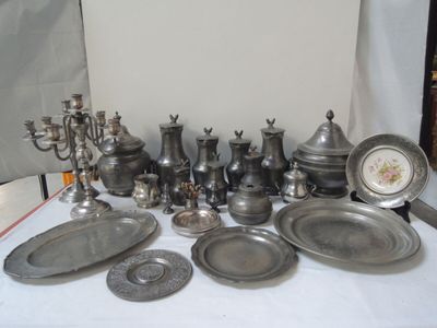 beaucoup d'objets en étain sur une table recouverte d'une nappe blanche