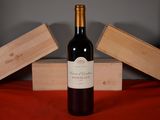 a bottle of wine sitting on a table next to two wooden boxes