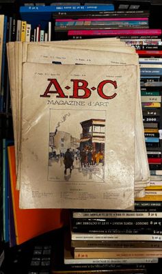 une pile de livres sur une étagère, à côté d'une autre pile de livres