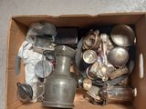 a cardboard box filled with silver items on the floor