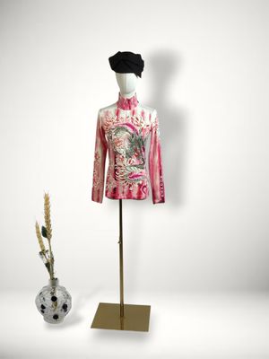 mannequin on a stand with a vase of flowers in front of it