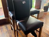 deux fauteuils en cuir noir dans une pièce au sol en parquet