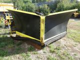 a snow plow that is sitting in the grass