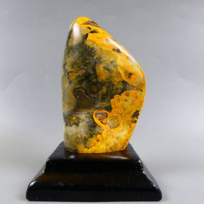 sculpture en marbre représentant une pierre jaune et noire posée sur un socle noir