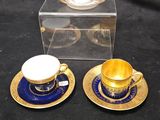 deux tasses et soucoupes posées sur une table, à côté d'une boîte transparente