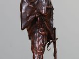 bronze statue of a man with a hat and a cane